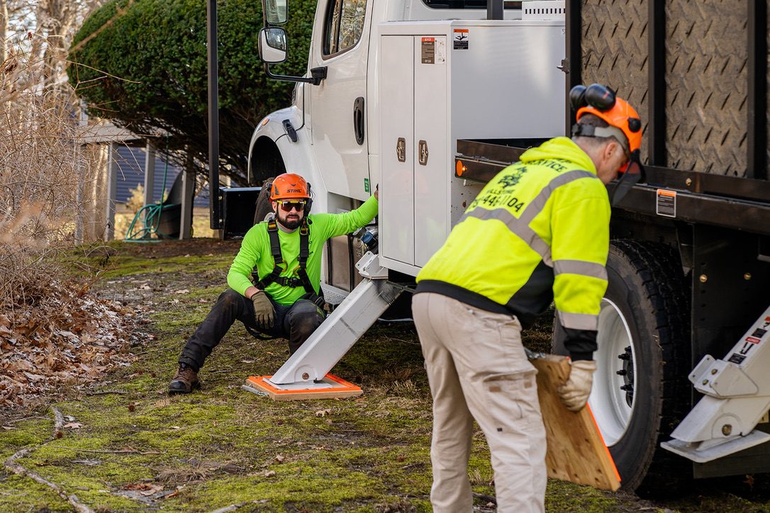 Pro-Stump crew stabilizing bucket truck on a lawn